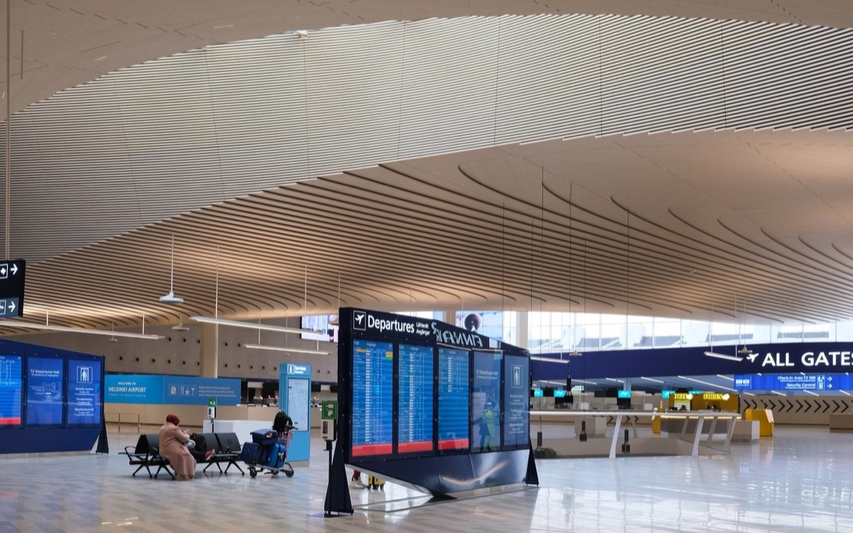 Sala de salidas de un aeropuerto internacional con un tablero de vuelos